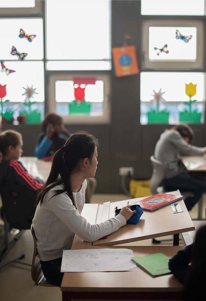 Schülerin in einer Klasse mit Fassadenfenstern