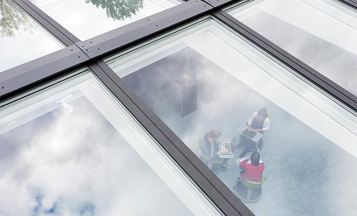 View from above into a school hall with working students through roof skylight