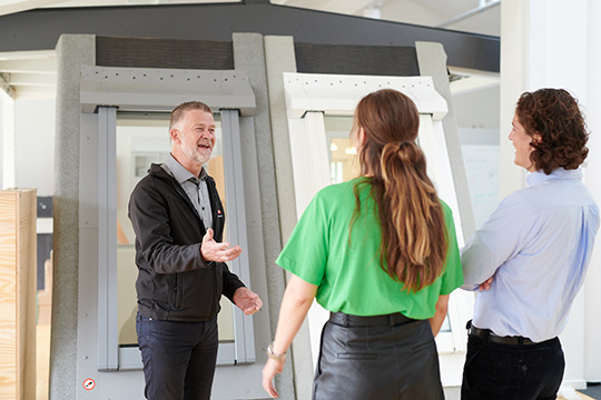 Man welcoming two other people to the work team