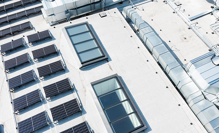 Dak met zonnepanelen en VELUX lichtstraten, een toonbeeld van duurzaam ontwerp.