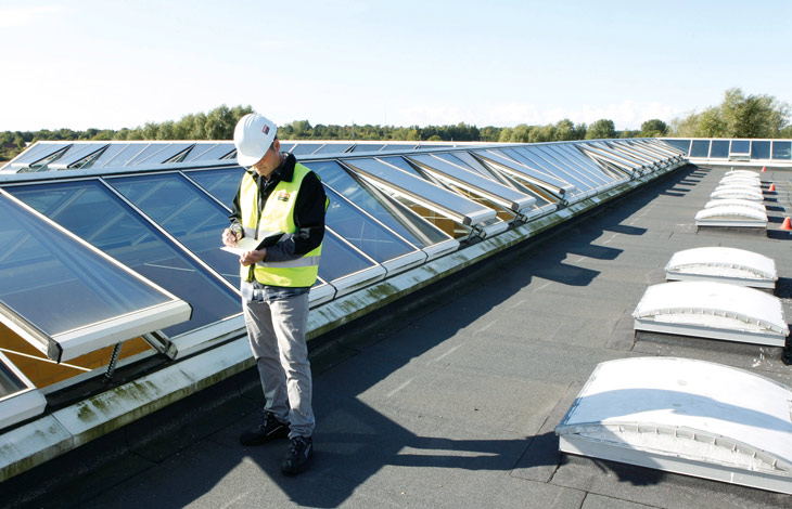 Technik VELUX Commercial instaluje i kontroluje jakość produktów odprowadzających dym i ciepło