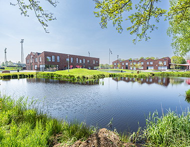 Buitenzicht op één van de nieuwe schoolgebouwen van Winkler Prins Veendam met grote ramen en geïntegreerde lichtstraten onder een zadeldak, bij daglicht gefotografeerd. Foto: Kasper Veenstra