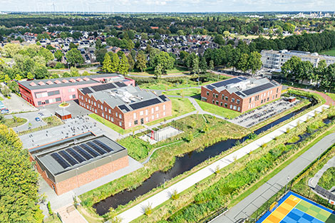 Luchtfoto van een onderwijsinstelling met bakstenen gebouwen en zonnepanelen op het dak. Foto: Kasper Veenstra
