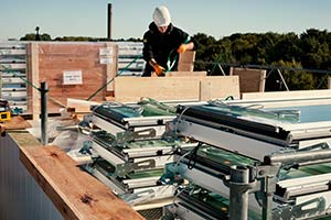 Un artisan emballe des verrières sur un toit